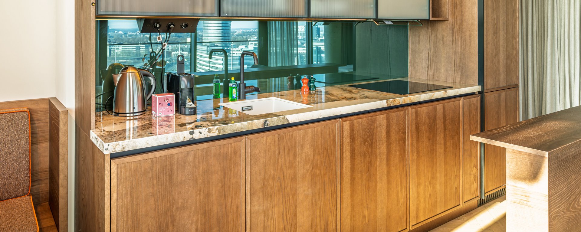 Hochwertige Holzküche im Apartment Home Skyline mit integrierten Geräten und viel Stauraum.