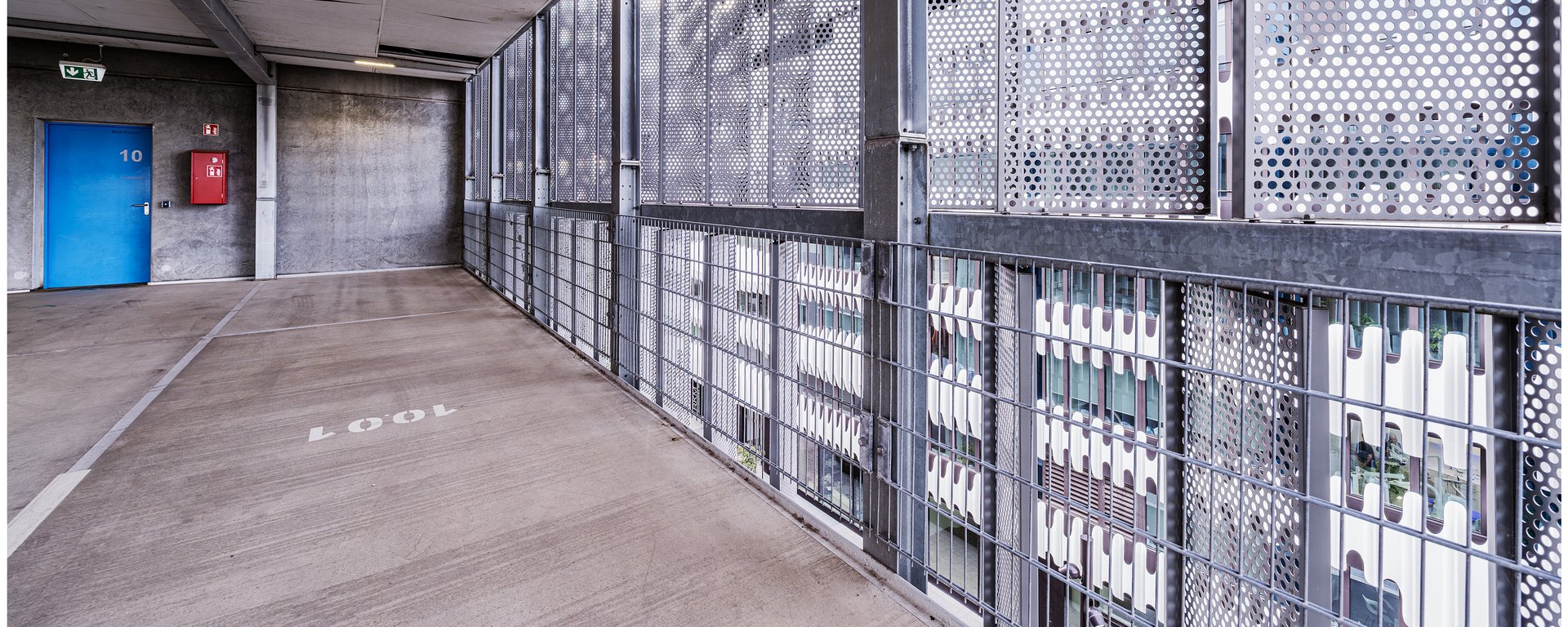 Ein großes, dunkles Gitter-Schiebetor, das einen Bereich innerhalb der Parkhausebene abgrenzt.