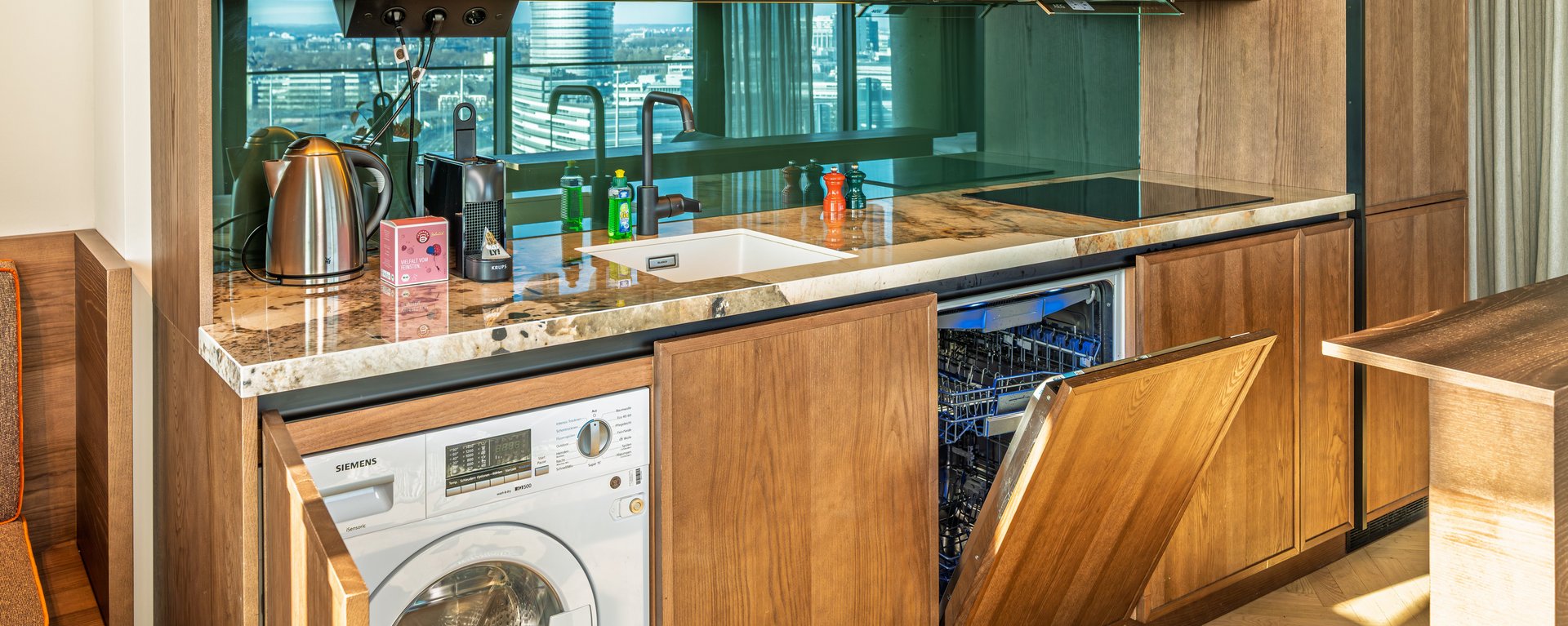 Voll ausgestattete Küchenzeile mit Waschmaschine und Geschirrspüler im The Zipper Apartment.
