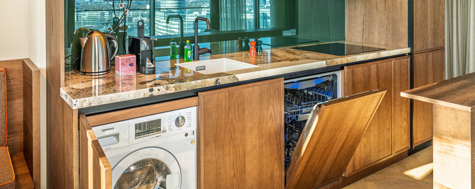 Voll ausgestattete Küchenzeile mit Waschmaschine und Geschirrspüler im The Zipper Apartment.