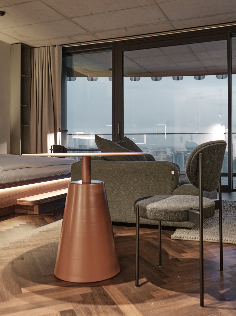 Apartment im The Zipper Düsseldorf mit Doppelbett, Lounge-Bereich, Designmöbeln und bodentiefen Fenstern mit Ausblick – ideal für Langzeitaufenthalte.