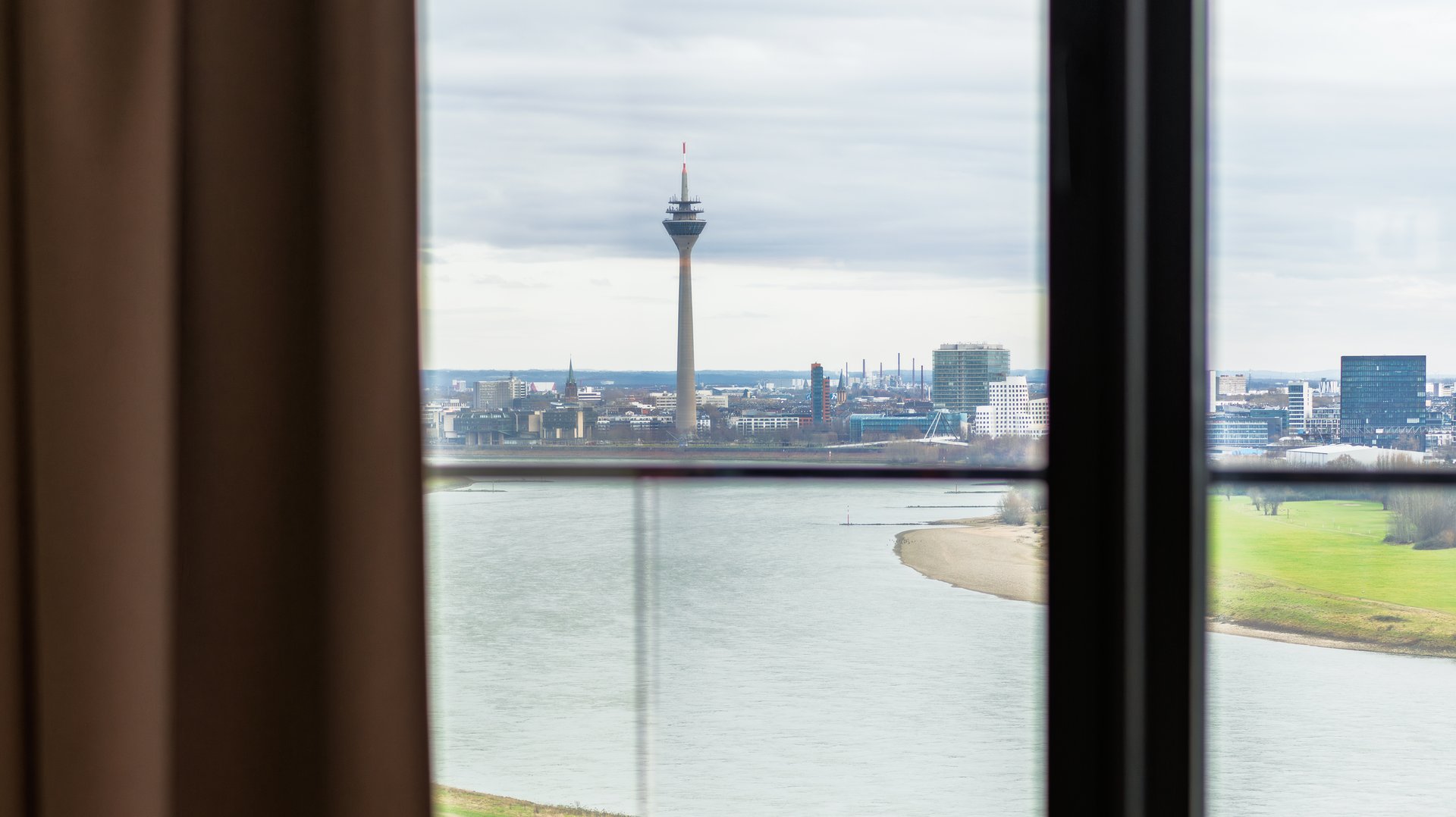 Beeindruckender Ausblick aus dem Fenster des Apartment Skyline auf den Rhein und die Düsseldorfer Skyline.