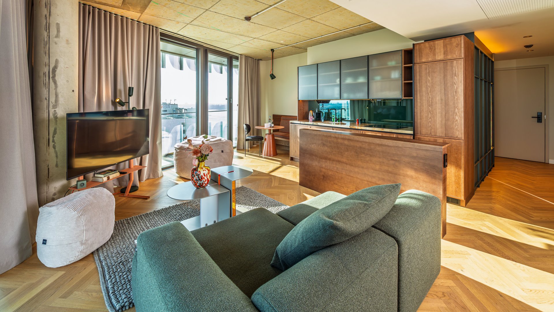 Helles Wohnzimmer im The Zipper mit modernem Mobiliar, Parkettboden und Zugang zur Loggia.