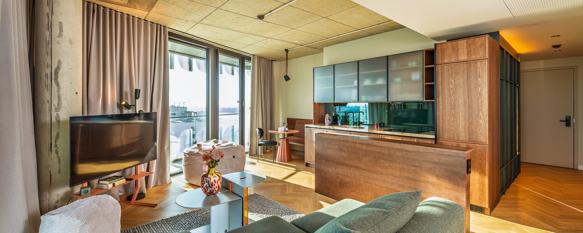 Helles Wohnzimmer im The Zipper mit modernem Mobiliar, Parkettboden und Zugang zur Loggia.