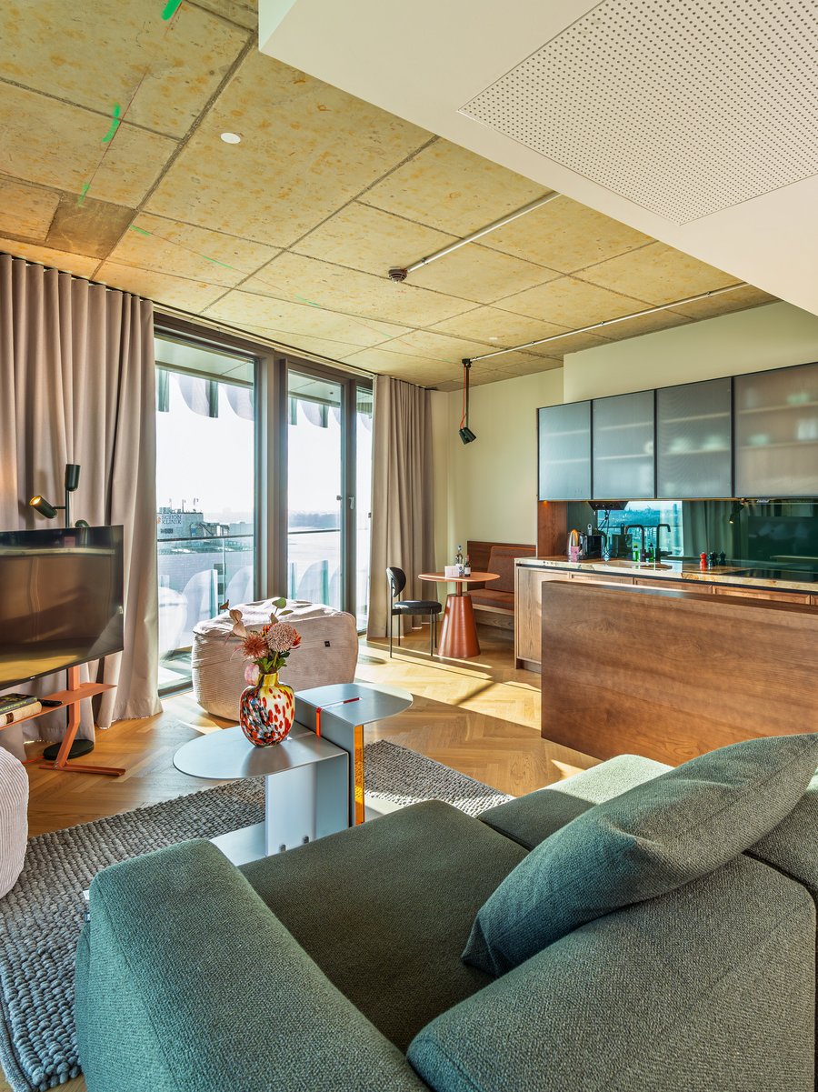 Helles Wohnzimmer im The Zipper mit modernem Mobiliar, Parkettboden und Zugang zur Loggia.