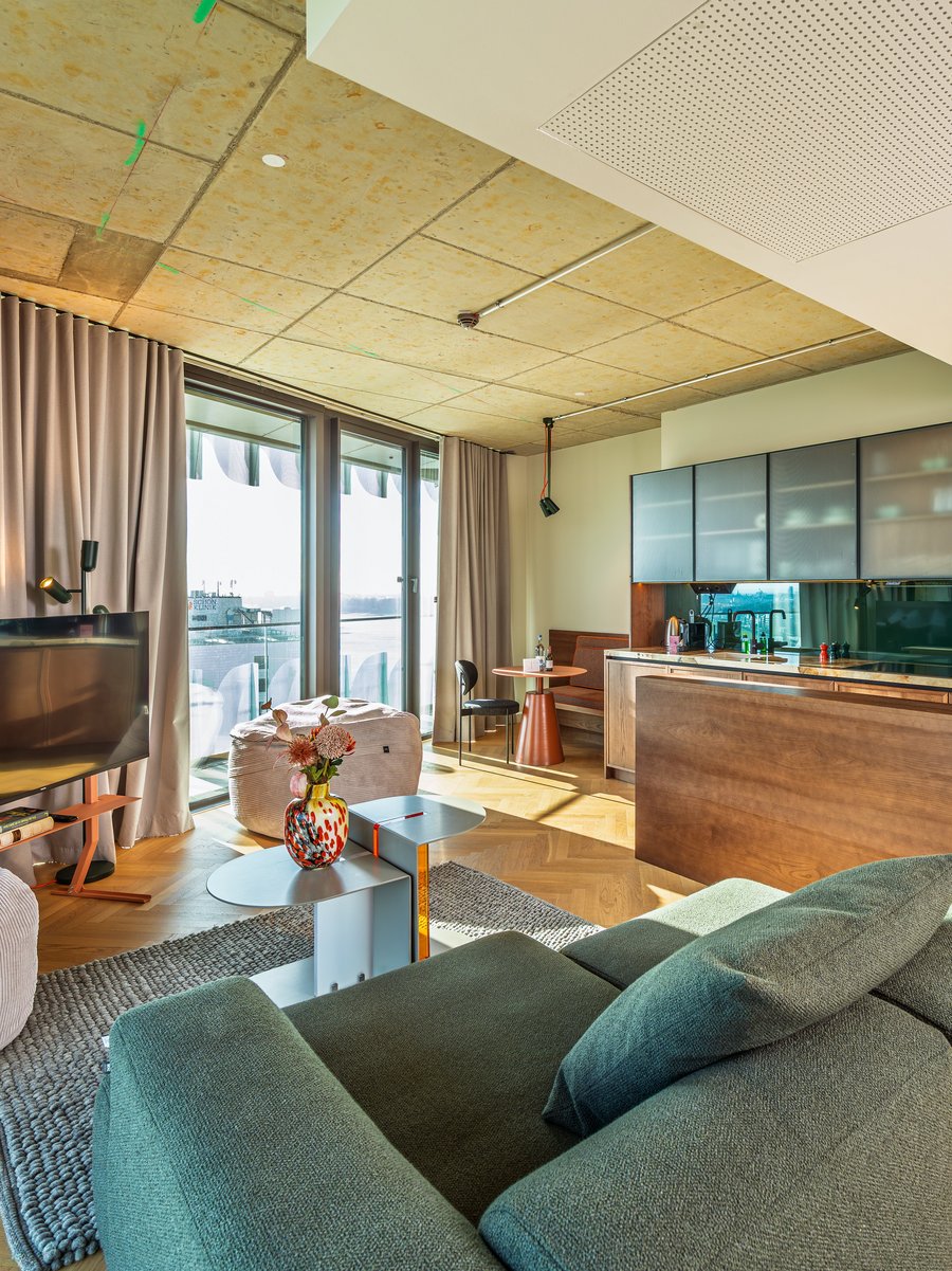 Helles Wohnzimmer im The Zipper mit modernem Mobiliar, Parkettboden und Zugang zur Loggia.