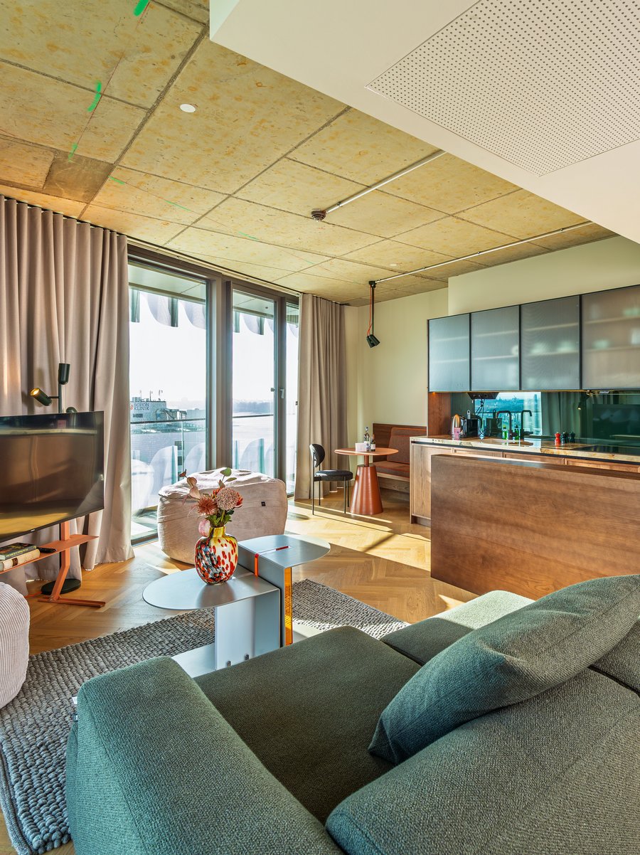 Helles Wohnzimmer im The Zipper mit modernem Mobiliar, Parkettboden und Zugang zur Loggia.