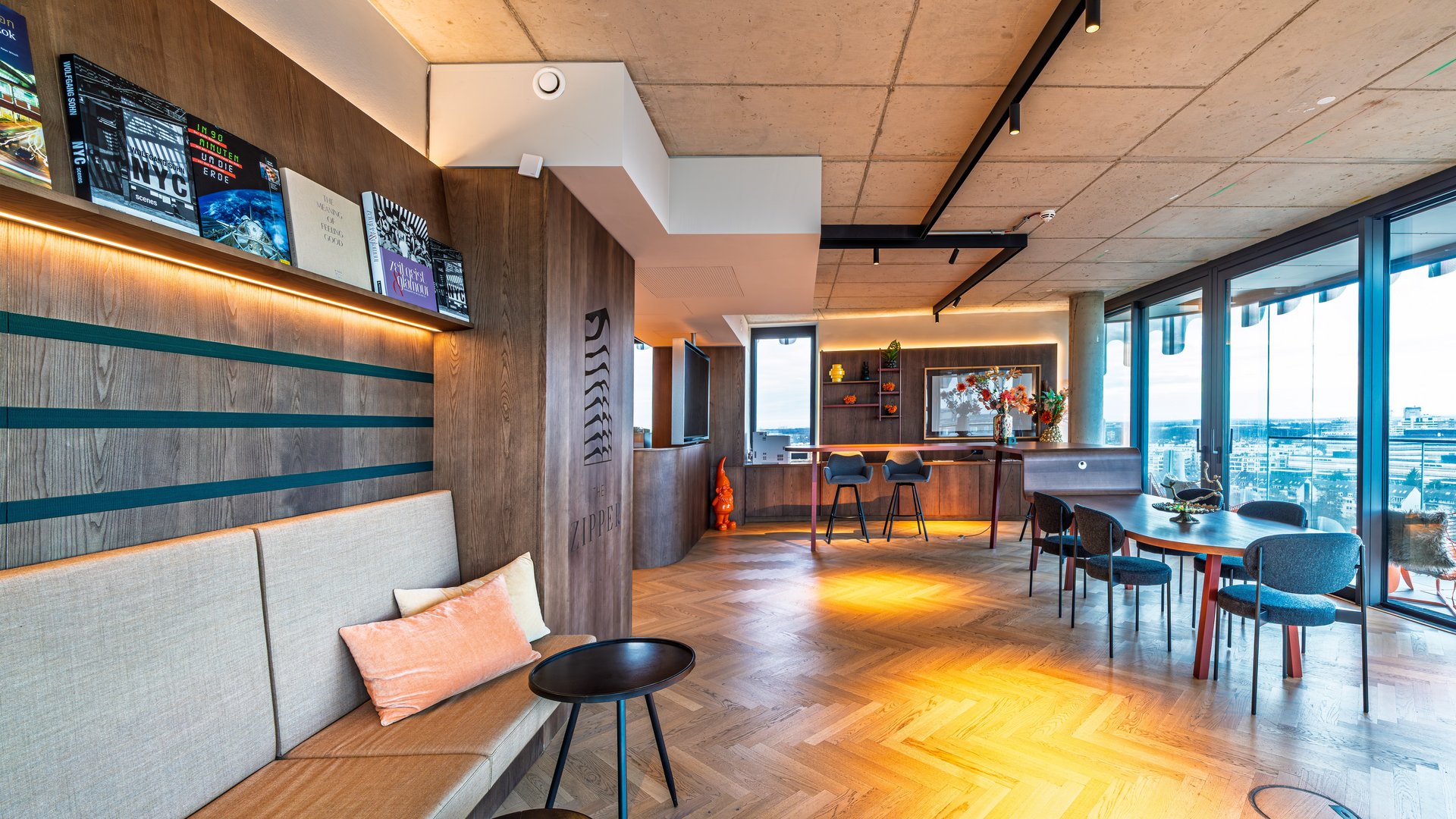 Gemütliche Sitzecke im Community-Bereich mit gepolsterten Bänken, kleinen Tischen und stilvoller Wandgestaltung.