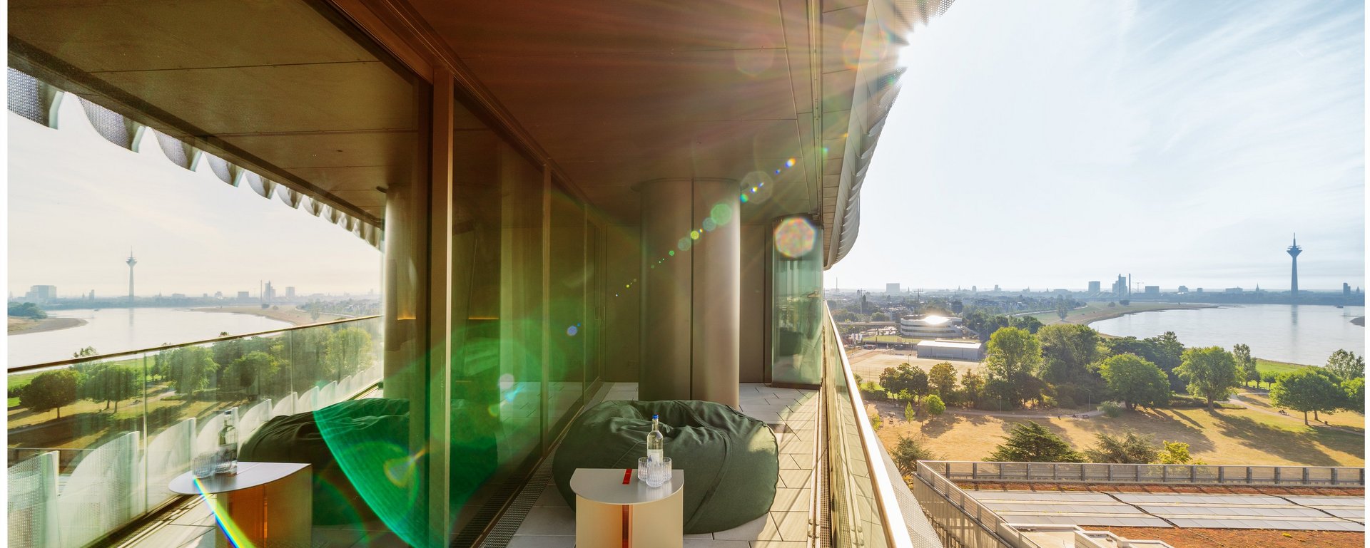 Balkon einer Hotelsuite mit Sitzmöbeln und Panoramablick über Düsseldorf im THE ZIPPER Hotel.