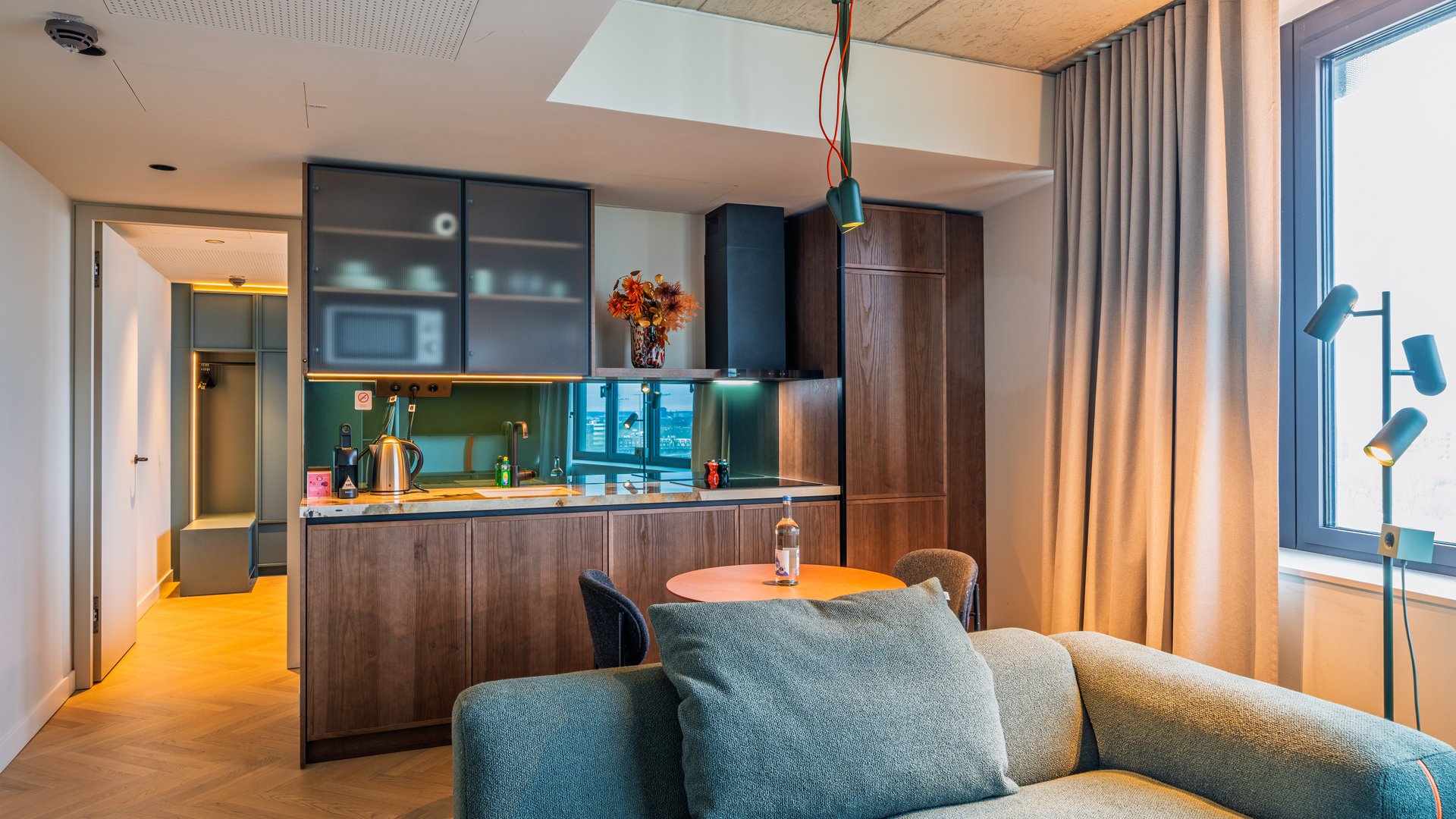 Blick über das Sofa in die offene Design-Küche der Apartment Suite im The Zipper Hotel.