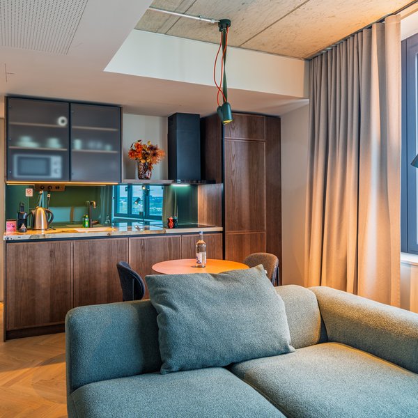 Blick über das Sofa in die offene Design-Küche der Apartment Suite im The Zipper Hotel.