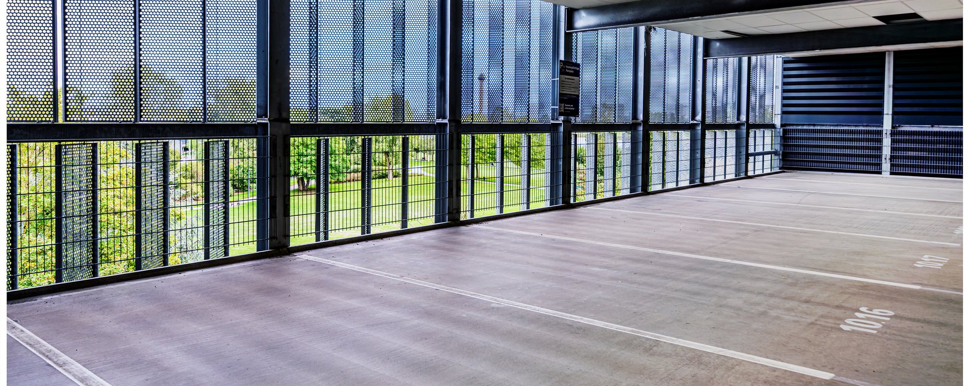 Ein leeres, gut ausgeleuchtetes Parkdeck mit nummerierten Stellflächen.