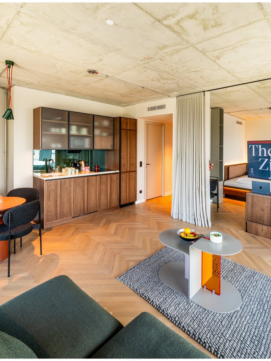 meeting_apartment__2_jpg Moderne Hotelsuite mit Küchenzeile, Esstisch, Sofa und TV im THE ZIPPER Hotel Düsseldorf.
