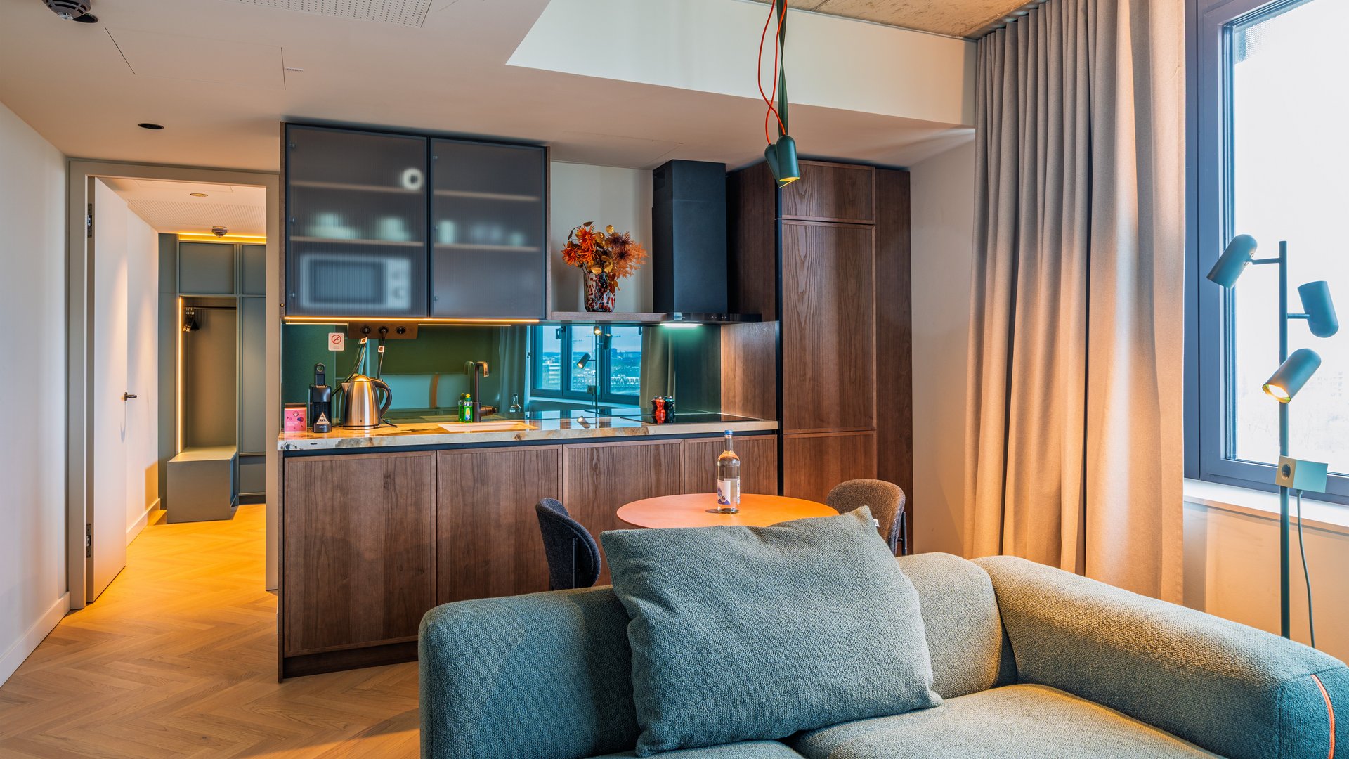 Blick über das Sofa in die offene Design-Küche der Apartment Suite im The Zipper Hotel.