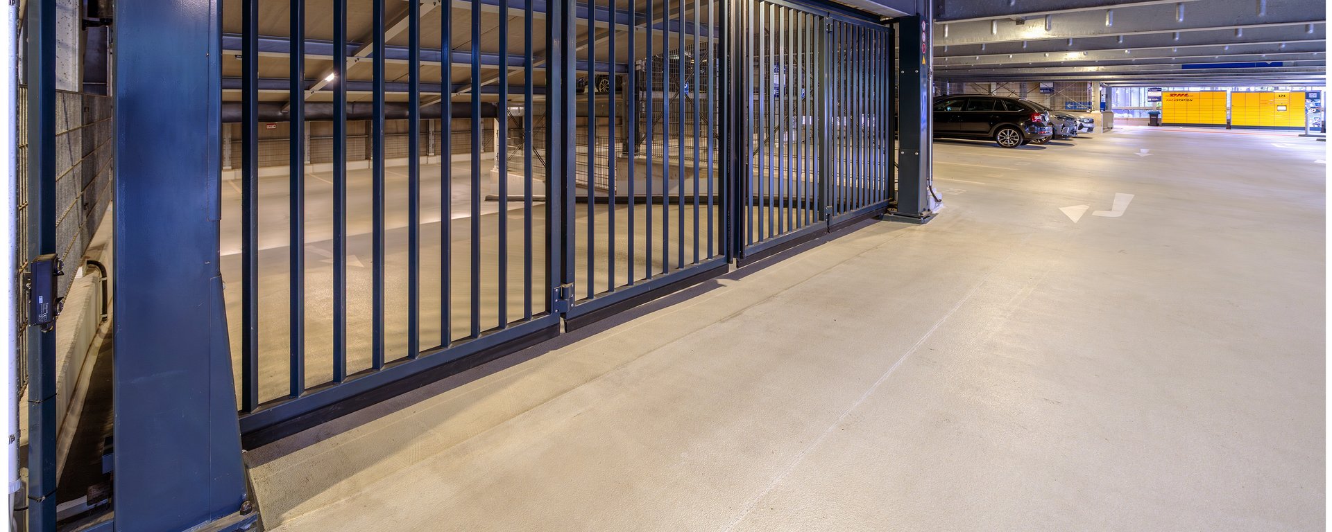 Ein leerer Parkplatz an einer Gitterwand.