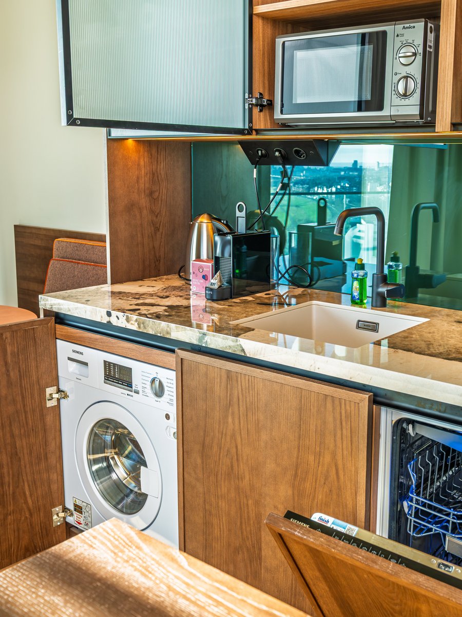 Nahaufnahme der Küchenausstattung inklusive Mikrowelle und Kaffeemaschine im Skyline Apartment.