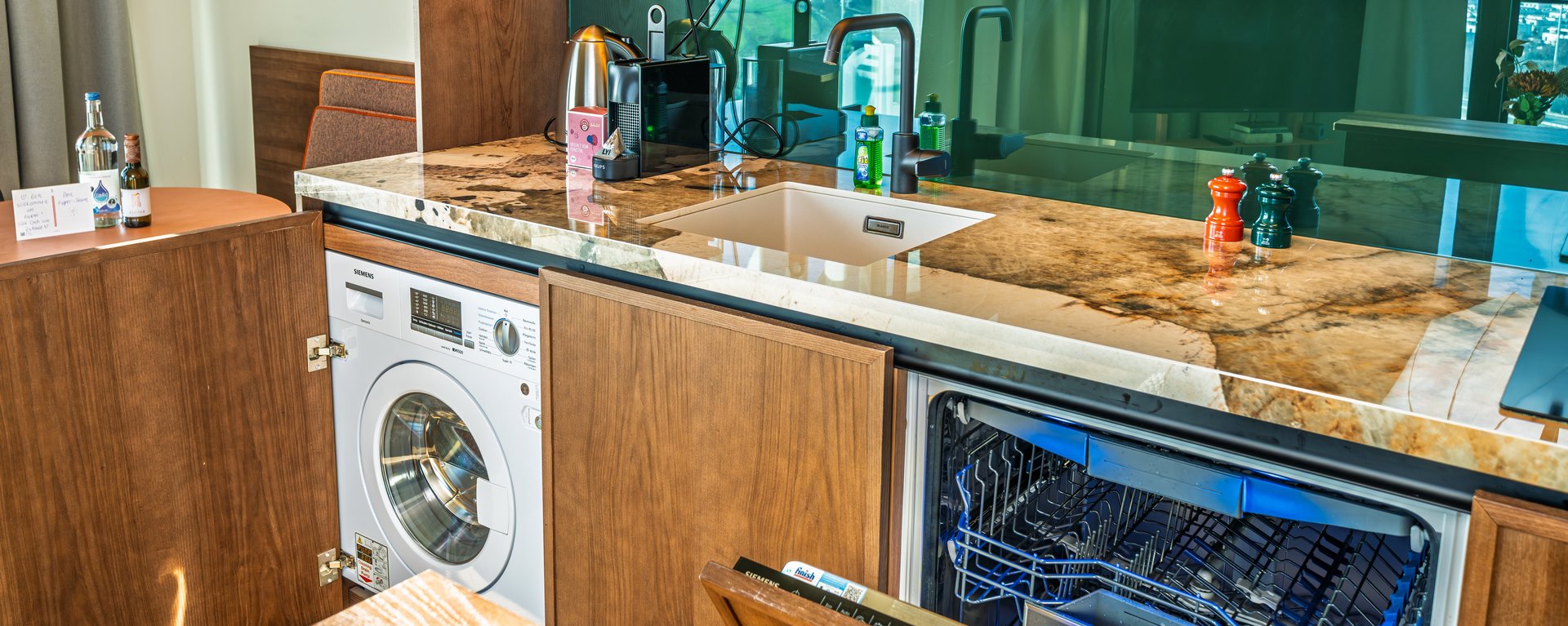 Nahaufnahme der Küchenausstattung inklusive Mikrowelle und Kaffeemaschine im Skyline Apartment.