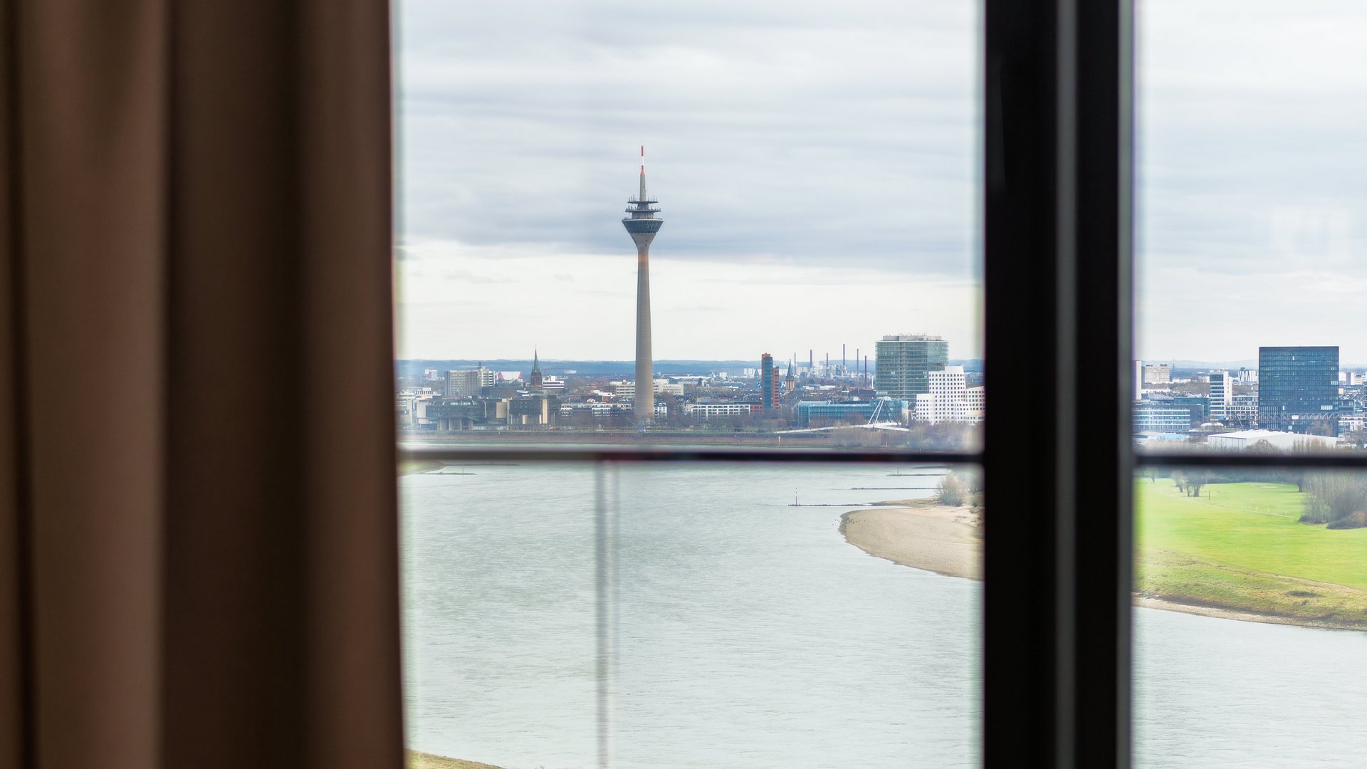 Beeindruckender Ausblick aus dem Fenster des Apartment Skyline auf den Rhein und die Düsseldorfer Skyline.