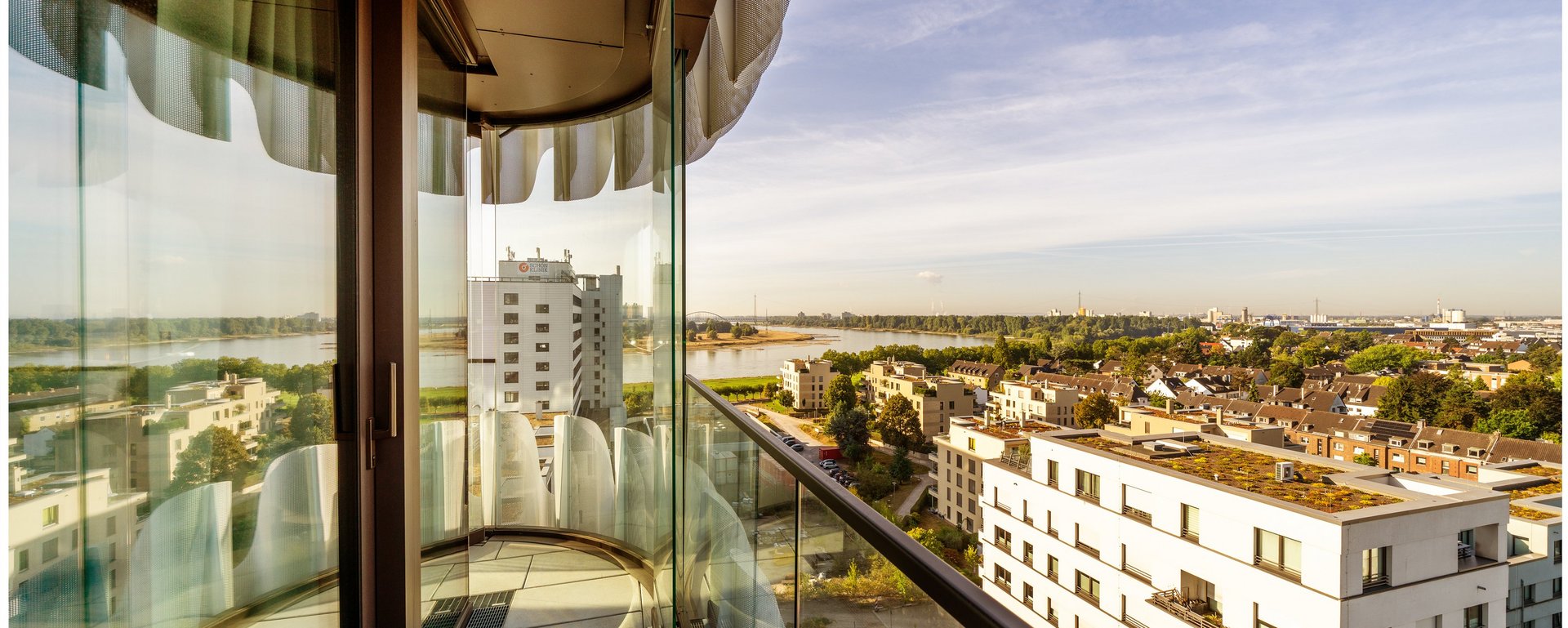 Balkon einer Suite mit Glasgeländer und weitem Blick über Düsseldorf im THE ZIPPER Hotel.