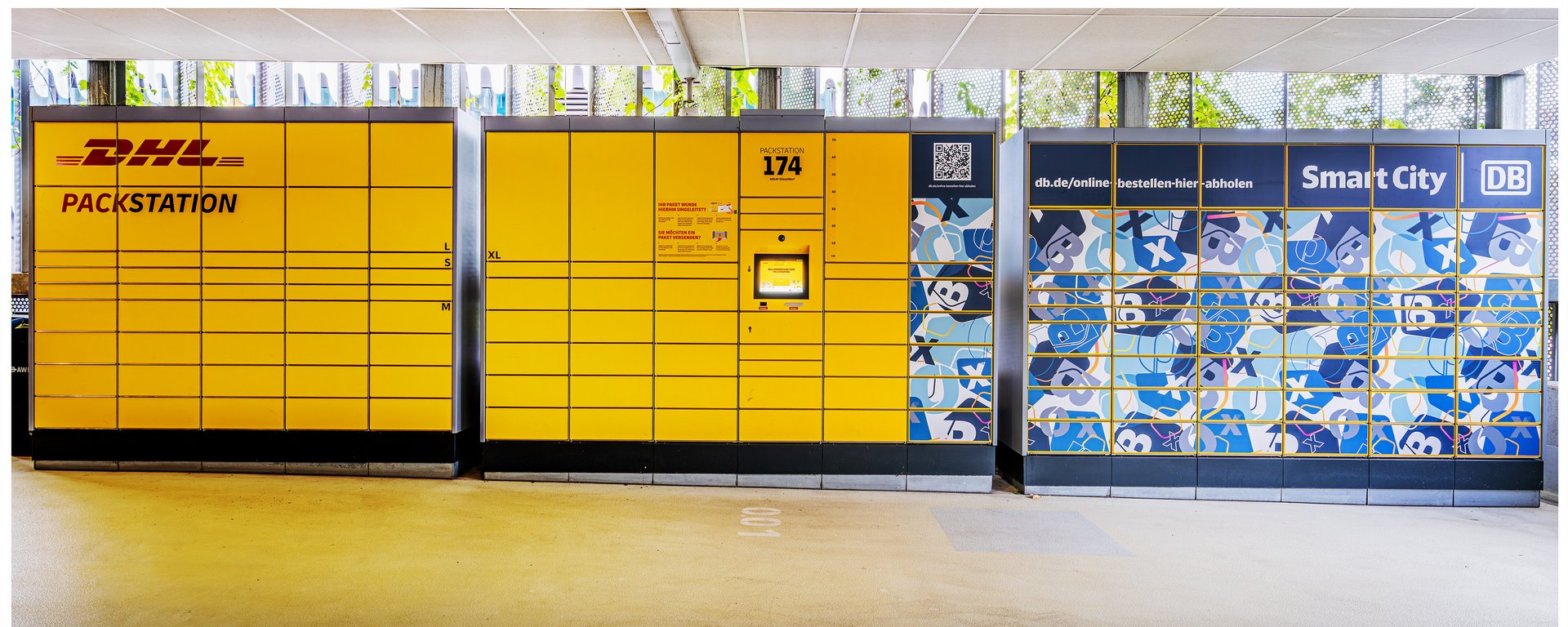 Eine lange, leuchtend gelbe DHL-Packstation.